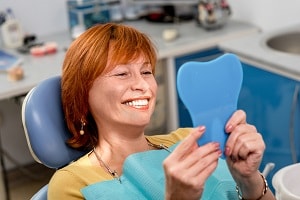 A senior patient loves her new implant smile