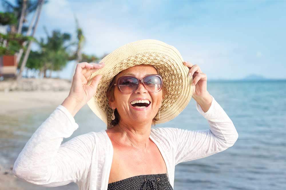 A smile woman in a sun hat on the beach